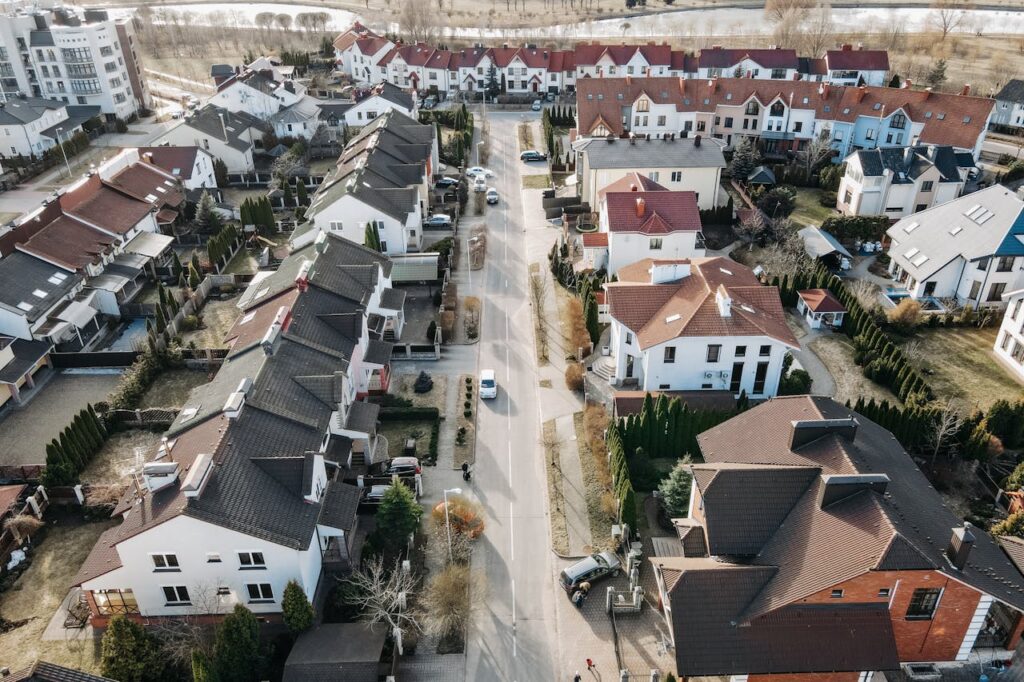 Aerial view of a suburban neighborhood with houses, streets, and cars.